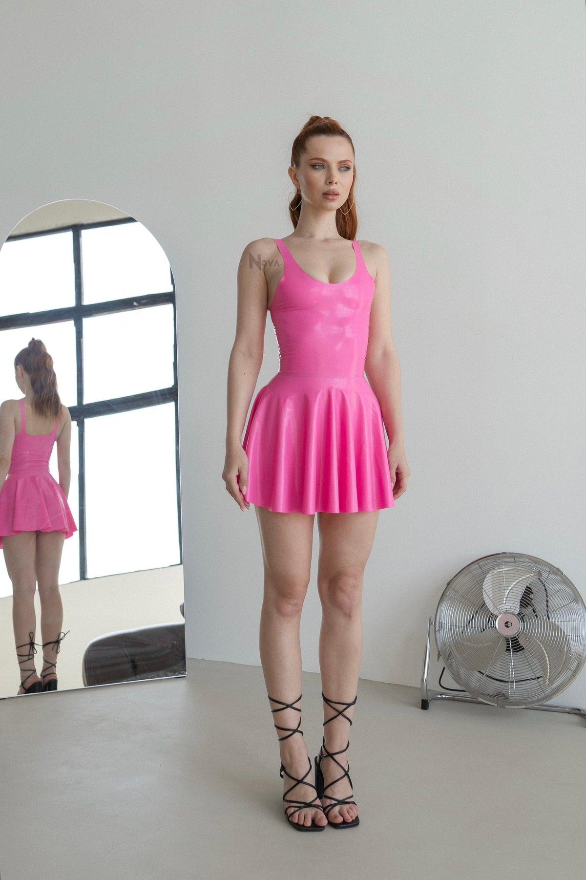 Pink latex mini dress with flared skirt, side view