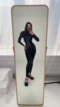 Black latex catsuit and corset seen in a full length mirror