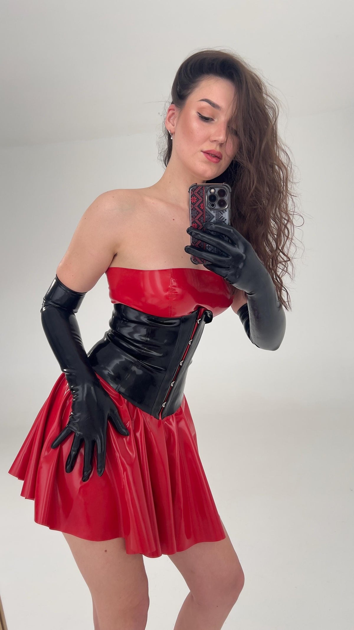 Close view of the black latex corset over the red dress