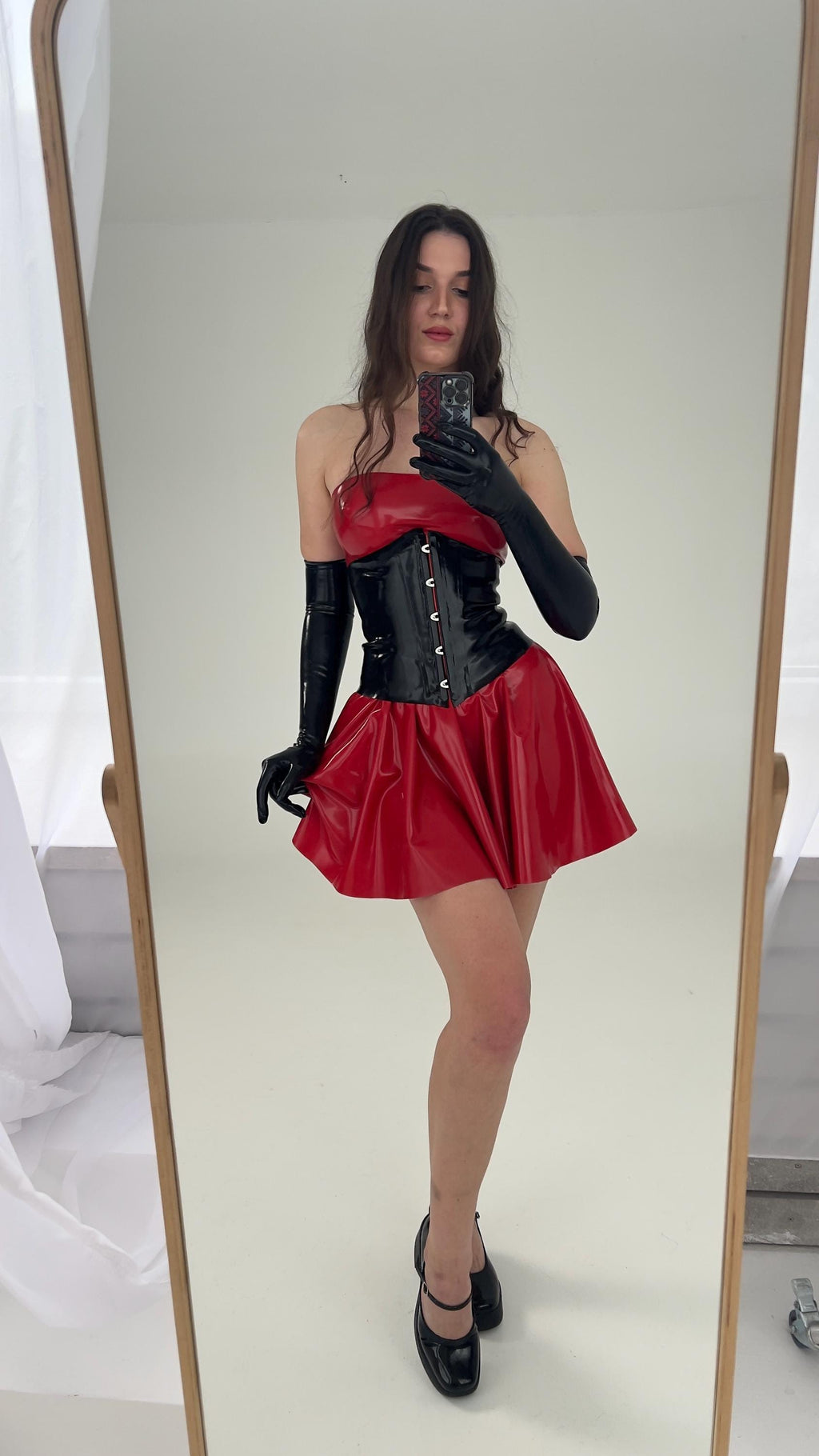 Red latex dress and corset seen in a full length mirror