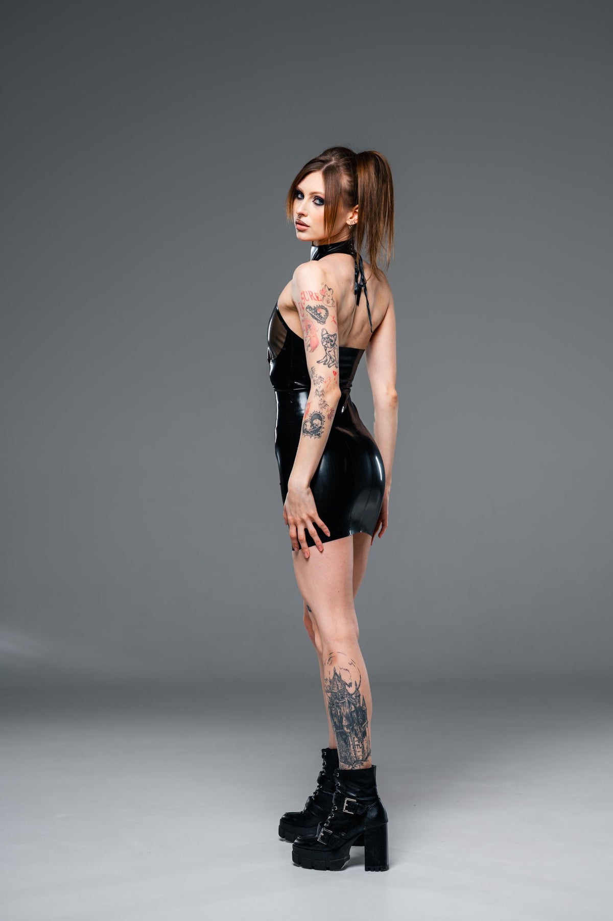 Black latex mini dress with high collar seen from the side